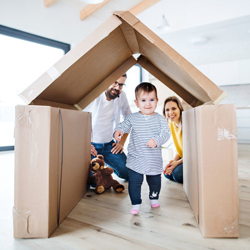 A portrait of young family with a toddler girl moving in new home.